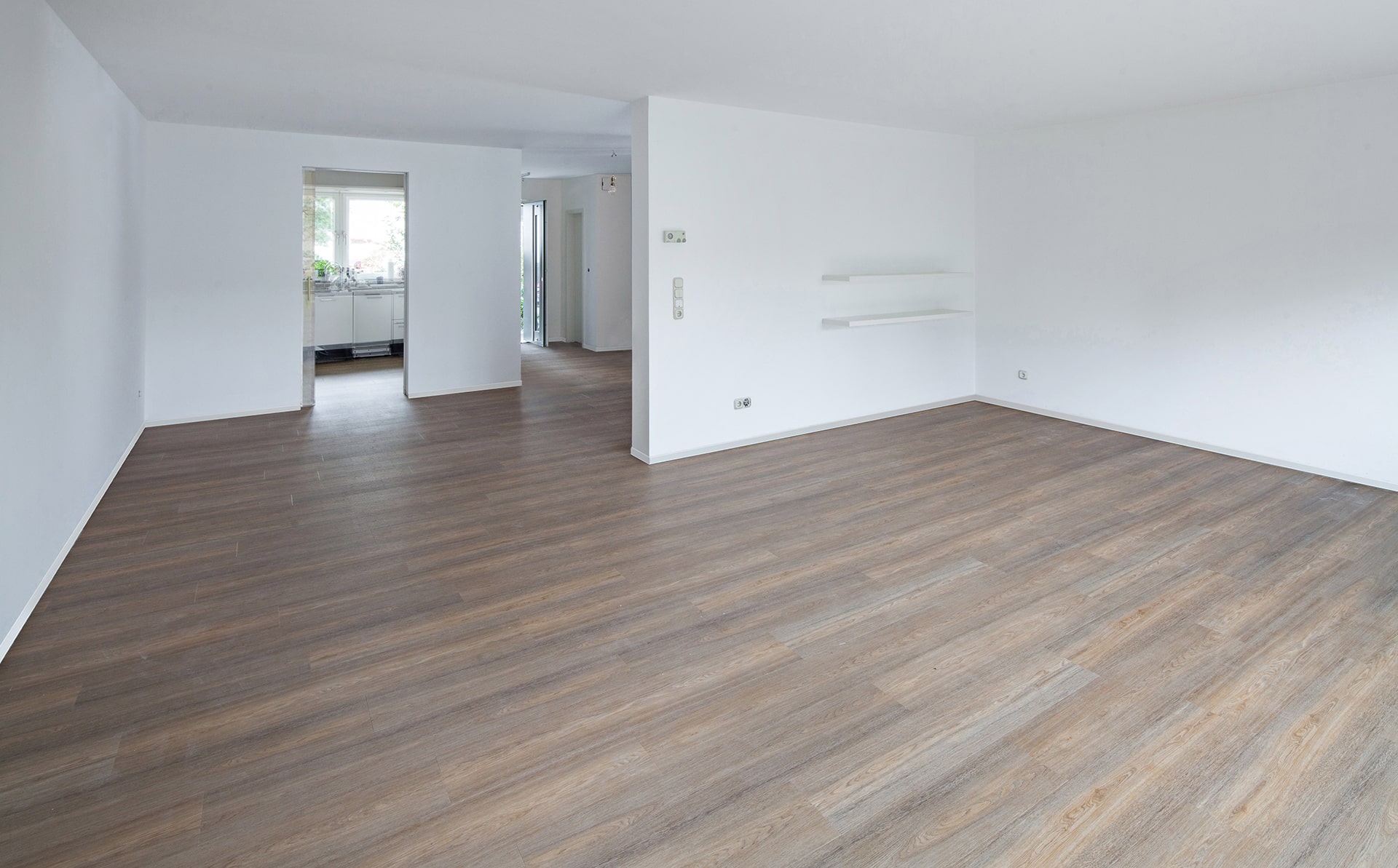 Ein leerer Raum mit Holzböden und weißen Wänden. Fussbodentechnik Schwallach -Bodenbeläge, Vinylbelag, Parkett - Neckaraue 7 - 71686 Remseck